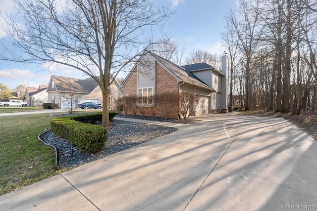 177 Summer Shade Dr, Howell, MI 48843 - view of home's exterior featuring brick siding, concrete driveway, a chimney, an attached garage, and a yard