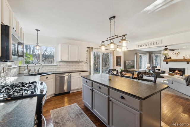 177 Summer Shade Dr, Howell, MI 48843 - kitchen featuring stainless steel appliances, dark countertops, a sink, and tasteful backsplash
