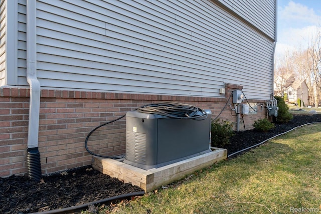 177 Summer Shade Dr, Howell, MI 48843 - exterior view of gas meter, central AC unit, brick siding, and electric meter