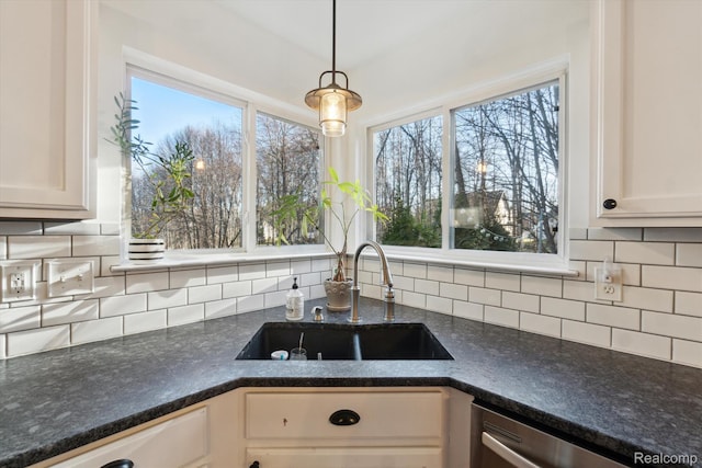 177 Summer Shade Dr, Howell, MI 48843 - kitchen featuring a sink, stainless steel dishwasher, tasteful backsplash, hanging light fixtures, and dark stone counters
