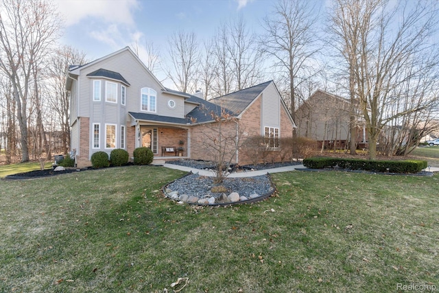 177 Summer Shade Dr, Howell, MI 48843 - traditional home featuring a front yard, a porch, and brick siding