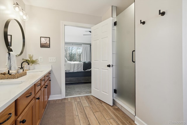 177 Summer Shade Dr, Howell, MI 48843 - ensuite bathroom with wood tiled floors, double vanity, a stall shower, and baseboards