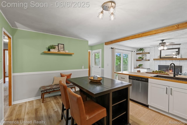 569 Lyon Blvd, South Lyon, MI 48178 - kitchen with open shelves, dishwasher, a sink, light wood-style floors, and white cabinetry