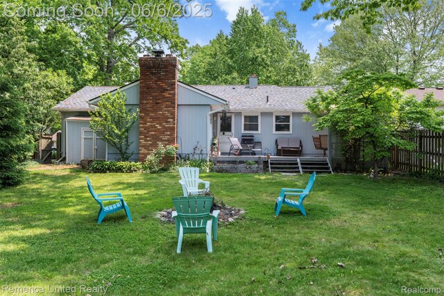 569 Lyon Blvd, South Lyon, MI 48178 - back of property featuring a chimney, roof with shingles, and a fire pit