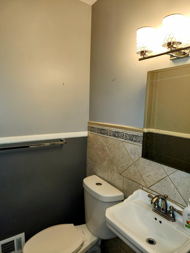 18830 San Quentin Dr, Lathrup Village, MI 48076 - bathroom featuring tile walls, a sink, toilet, and wainscoting