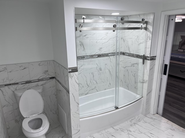 18830 San Quentin Dr, Lathrup Village, MI 48076 - bathroom with bath / shower combo with glass door, toilet, marble look tiles, and tile walls