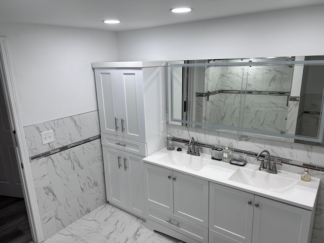 18830 San Quentin Dr, Lathrup Village, MI 48076 - bathroom featuring a marble finish shower, double vanity, recessed lighting, tile walls, and a wainscoted wall