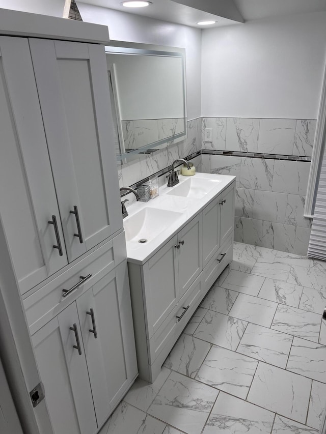 18830 San Quentin Dr, Lathrup Village, MI 48076 - full bathroom with marble finish floors, double vanity, a wainscoted wall, recessed lighting, and tile walls