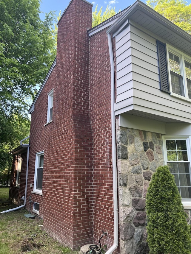 18830 San Quentin Dr, Lathrup Village, MI 48076 - view of home's exterior featuring a chimney, stone siding, and brick siding