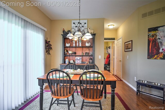 28329 Cottage Ln, New Hudson, MI 48165 - dining room with a chandelier, dark wood finished floors, and baseboards