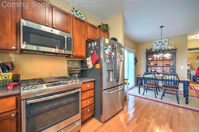 28329 Cottage Ln, New Hudson, MI 48165 - kitchen featuring stainless steel appliances, a chandelier, light wood-style flooring, decorative light fixtures, and brown cabinets