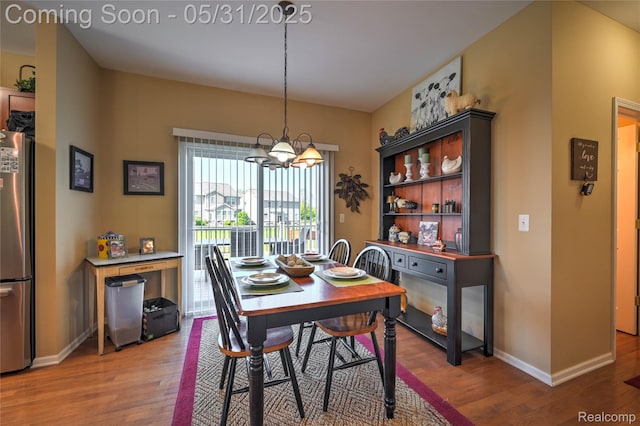 28329 Cottage Ln, New Hudson, MI 48165 - dining room featuring wood finished floors, a chandelier, and baseboards