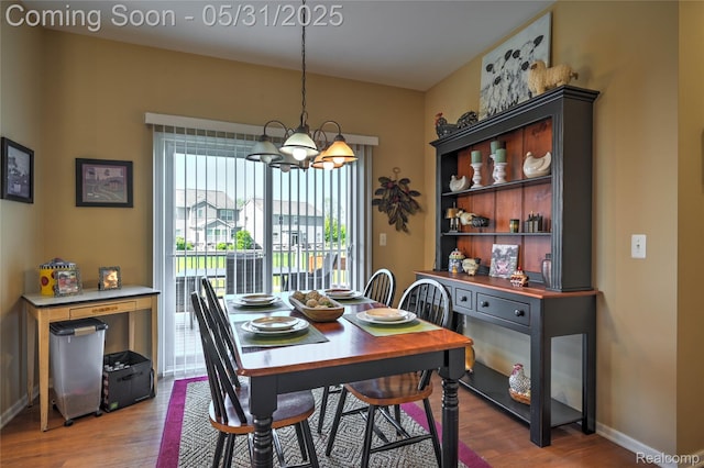 28329 Cottage Ln, New Hudson, MI 48165 - dining area featuring wood finished floors, a chandelier, and baseboards