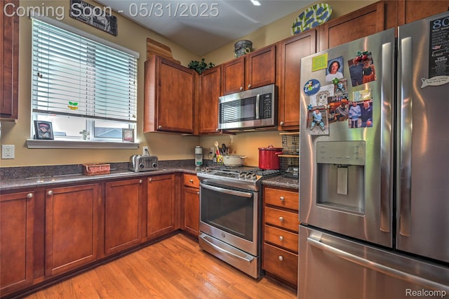 28329 Cottage Ln, New Hudson, MI 48165 - kitchen with stainless steel appliances, light wood-type flooring, and brown cabinets