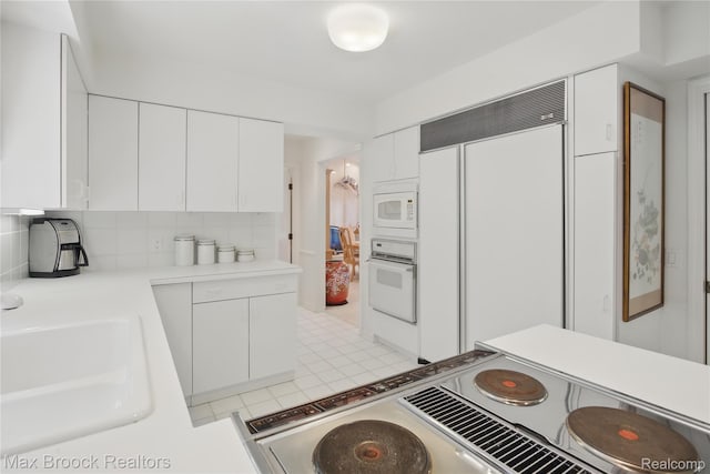 1816 Ledbury Dr, Bloomfield Hills, MI 48304 - kitchen featuring built in appliances, a sink, white cabinetry, and backsplash