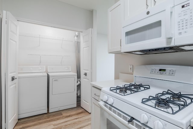 157 Hunters Ln NE, Rockford, MI 49341 - kitchen featuring white appliances, independent washer and dryer, light countertops, light wood-style flooring, and white cabinetry