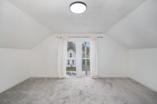 723 Baxter St SE, Grand Rapids, MI 49503 - bonus room with a textured ceiling, vaulted ceiling, baseboards, and carpet floors