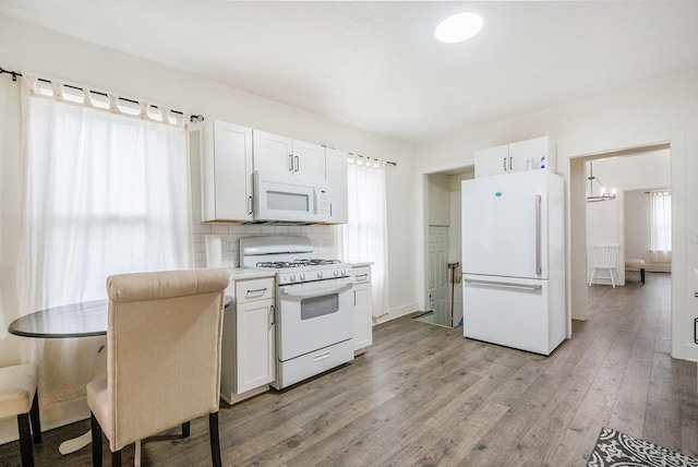 723 Baxter St SE, Grand Rapids, MI 49503 - kitchen with white appliances, light wood-style floors, healthy amount of natural light, and white cabinets