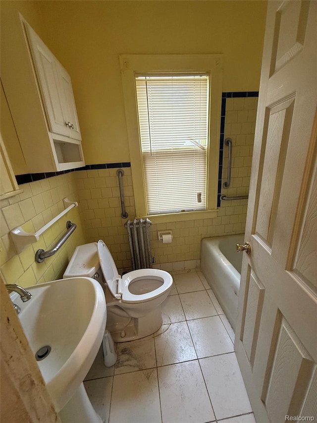 8071 Elgin St, Detroit, MI 48234 - bathroom with radiator, tile walls, toilet, a sink, and wainscoting