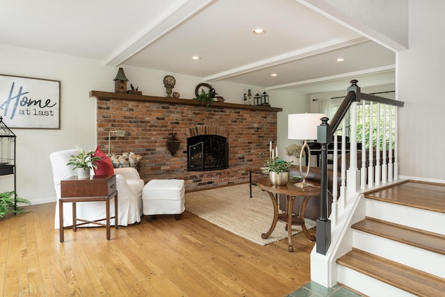 647 S Spinningwheel Ln, Michigan, MI 48304 - living area featuring beamed ceiling, wood finished floors, stairs, a brick fireplace, and baseboards