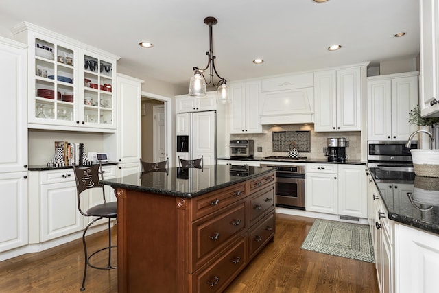 647 S Spinningwheel Ln, Michigan, MI 48304 - kitchen featuring stainless steel appliances, white cabinets, custom exhaust hood, glass insert cabinets, and dark wood-type flooring