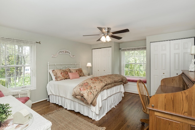 647 S Spinningwheel Ln, Michigan, MI 48304 - bedroom featuring two closets, dark wood-type flooring, ceiling fan, and baseboards