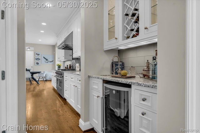 499 Catalpa Dr, Birmingham, MI 48009 - indoor dry bar with beverage cooler, stainless steel stove, under cabinet range hood, dark wood-style floors, and recessed lighting