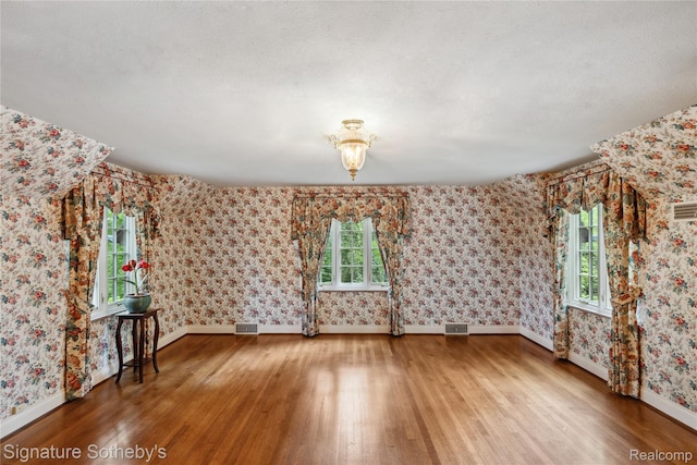 401 Dunston Rd, Bloomfield Hills, MI 48304 - empty room featuring hardwood / wood-style flooring, baseboards, wallpapered walls, and a textured ceiling