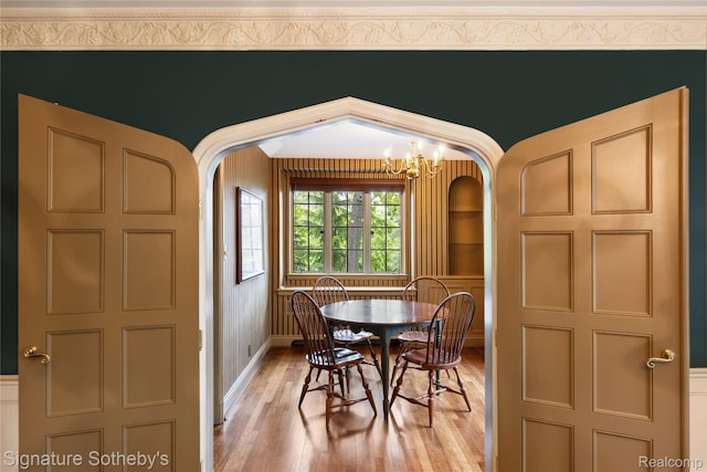 401 Dunston Rd, Bloomfield Hills, MI 48304 - dining space featuring arched walkways, light wood-style floors, a chandelier, and baseboards
