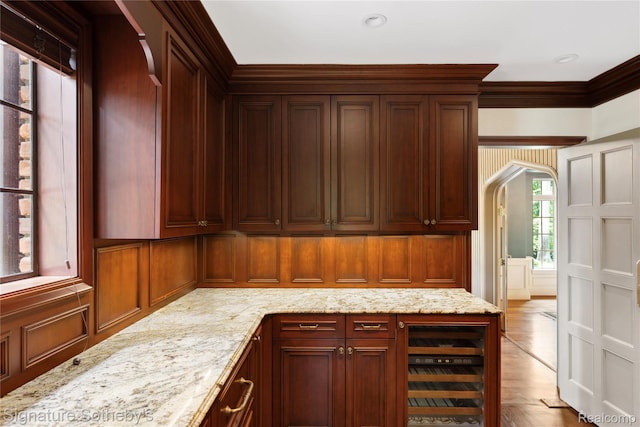 401 Dunston Rd, Bloomfield Hills, MI 48304 - kitchen featuring beverage cooler, light stone countertops, arched walkways, wood finished floors, and crown molding
