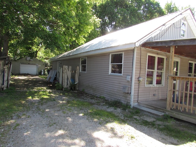 814 Ira Ave, Kalamazoo, MI 49048 - view of property exterior with a deck, driveway, a garage, an outbuilding, and metal roof