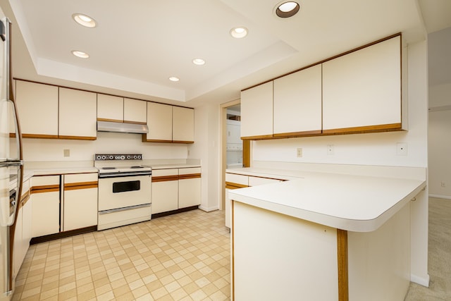 2125208 Nature Cove Ct, Ann Arbor, MI 48104 - kitchen with white electric range oven, a peninsula, a raised ceiling, recessed lighting, and under cabinet range hood