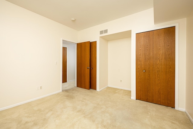 2125208 Nature Cove Ct, Ann Arbor, MI 48104 - unfurnished bedroom with light carpet, baseboards, and multiple closets