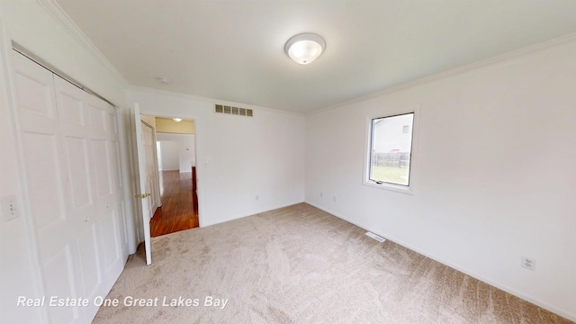 4984 Cactus Dr, Saginaw, MI 48603 - unfurnished bedroom featuring ornamental molding, a closet, light carpet, and baseboards