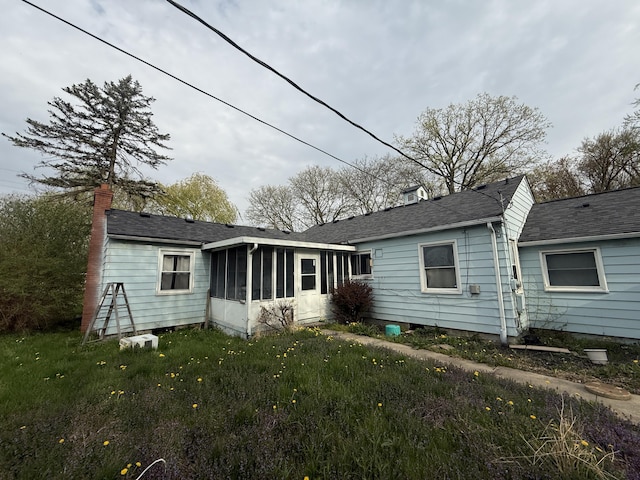21338 Orchard Lake Rd, Farmington Hills, MI 48336 - rear view of house featuring a sunroom, a chimney, a yard, and a shingled roof