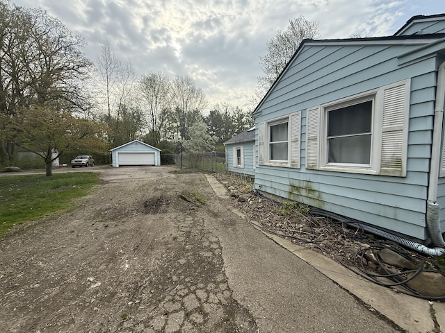21338 Orchard Lake Rd, Farmington Hills, MI 48336 - view of property exterior with dirt driveway, a garage, and an outdoor structure