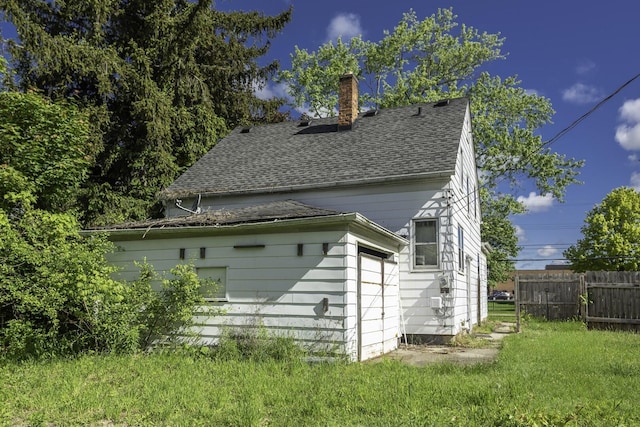566 Davis St, Ypsilanti, MI 48198 - rear view of house with a shingled roof and a chimney