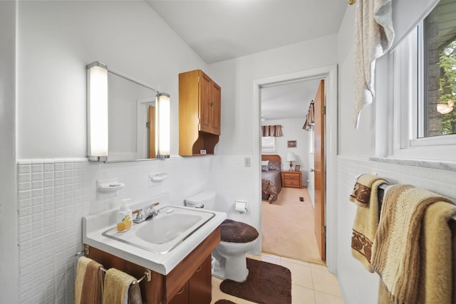 2074 Campbell Dr, Jackson, MI 49202 - bathroom featuring vanity, toilet, tile patterned flooring, wainscoting, and tile walls