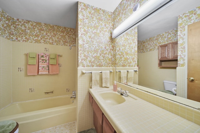 2074 Campbell Dr, Jackson, MI 49202 - full bathroom with wallpapered walls, toilet, vanity, and washtub / shower combination
