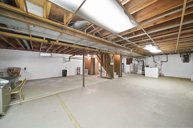 2074 Campbell Dr, Jackson, MI 49202 - unfinished below grade area featuring gas water heater, electric panel, washer / dryer, and stairs