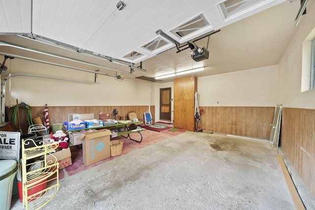 2074 Campbell Dr, Jackson, MI 49202 - garage featuring wainscoting, wood walls, and a garage door opener