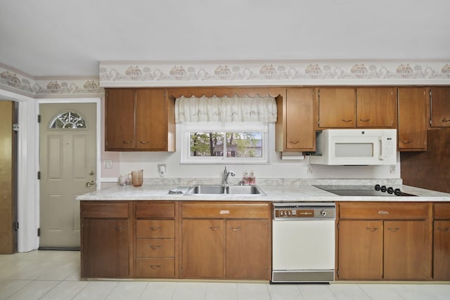 2074 Campbell Dr, Jackson, MI 49202 - kitchen featuring white appliances, a sink, light countertops, and brown cabinetry