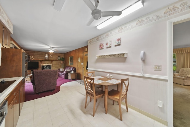 2074 Campbell Dr, Jackson, MI 49202 - dining area featuring a ceiling fan, wooden walls, and a brick fireplace
