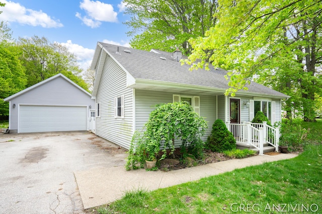5906 Henry St, Norton Shores, MI 49441 - view of front of home with a detached garage, an outbuilding, and roof with shingles