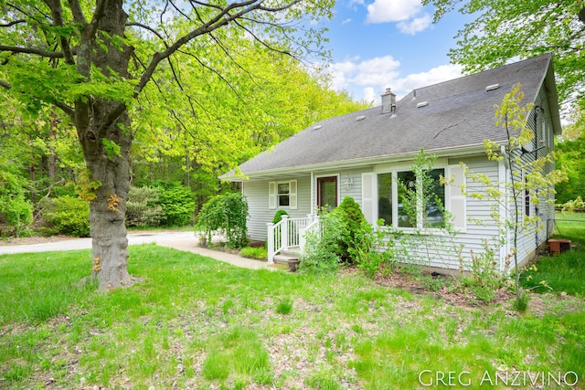 5906 Henry St, Norton Shores, MI 49441 - back of property featuring a chimney, a yard, and a shingled roof