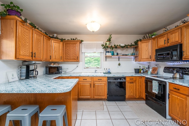 5906 Henry St, Norton Shores, MI 49441 - kitchen with black appliances, a kitchen bar, a peninsula, and brown cabinets