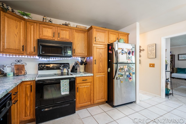 5906 Henry St, Norton Shores, MI 49441 - kitchen featuring black appliances, light tile patterned flooring, brown cabinetry, and decorative backsplash