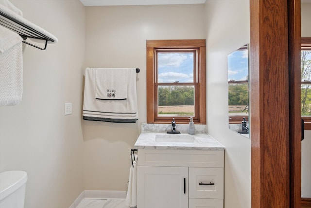 10200 Jerome Rd N, Jerome, MI 49249 - half bath featuring toilet, baseboards, vanity, and marble look tile flooring