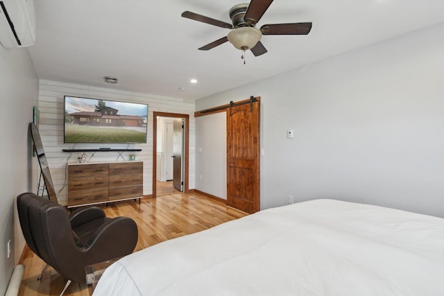 10200 Jerome Rd N, Jerome, MI 49249 - bedroom with a wall mounted air conditioner, light wood finished floors, a barn door, recessed lighting, and ceiling fan