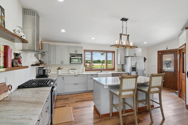 10200 Jerome Rd N, Jerome, MI 49249 - kitchen with appliances with stainless steel finishes, wall chimney exhaust hood, open shelves, a sink, and light stone counters